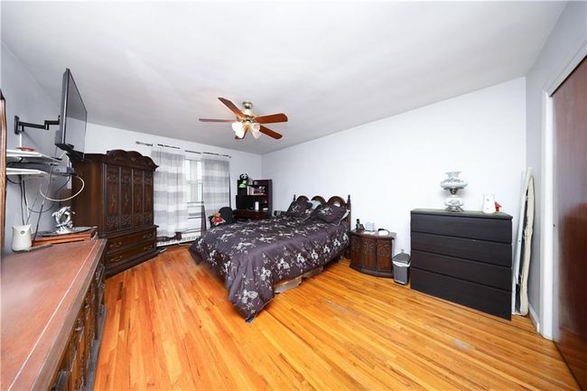 Bedroom with wood finished floors and a ceiling fan | Image 16