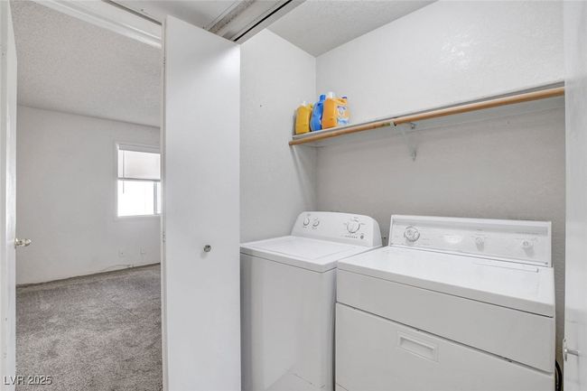 Clothes washing area featuring washing machine and clothes dryer, carpet, and laundry area | Image 25