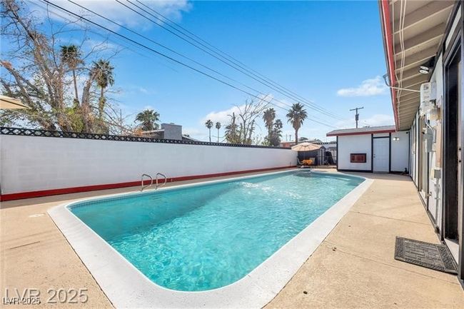 View of swimming pool featuring a fenced backyard and a patio | Image 26