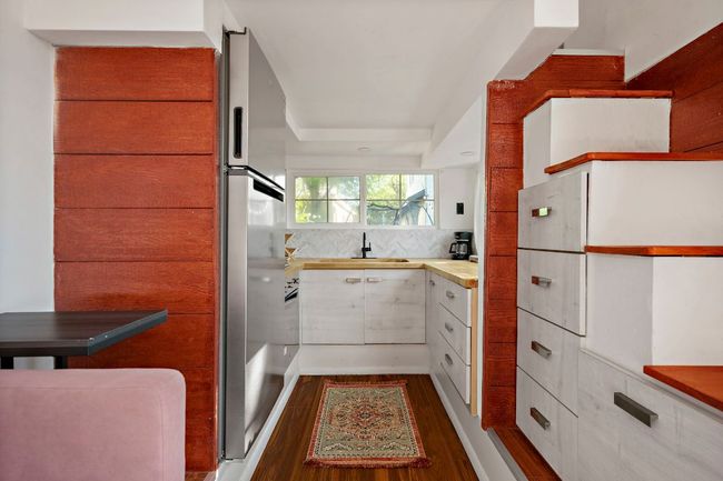 Kitchen with dark wood finished floors, tasteful backsplash, a sink, and light countertops | Image 29