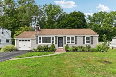 Ranch-style home featuring a garage and a front lawn | Image 1