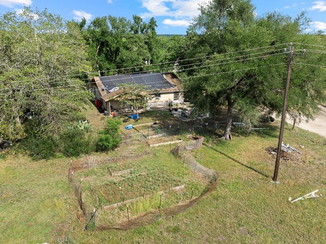 View of grassy yard with a garden and a view of trees | Image 6