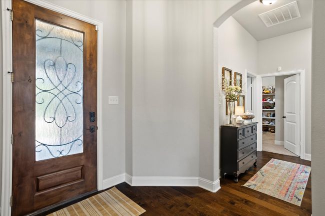 Entryway featuring arched walkways, dark wood-style flooring, visible vents, and baseboards | Image 5