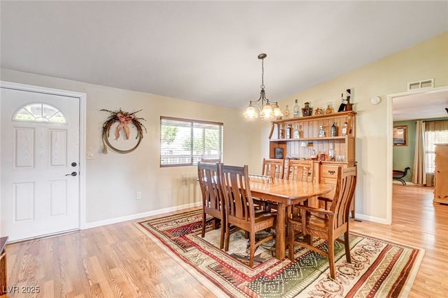 Dining space featuring a chandelier, lofted ceiling, and light wood-style flooring | Image 25
