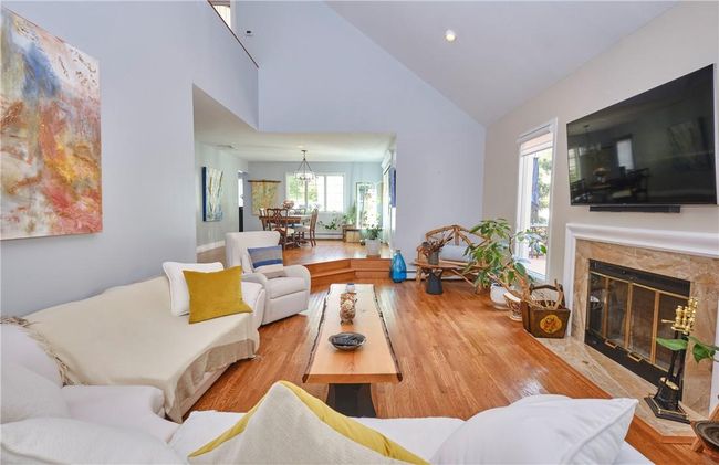 Living room featuring light hardwood / wood-style flooring, high vaulted ceiling, and a premium fireplace | Image 15