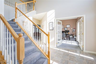 Stairs with a high ceiling and french doors | Image 3