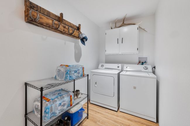 Laundry room with cabinet space, independent washer and dryer, and light wood-type flooring | Image 18