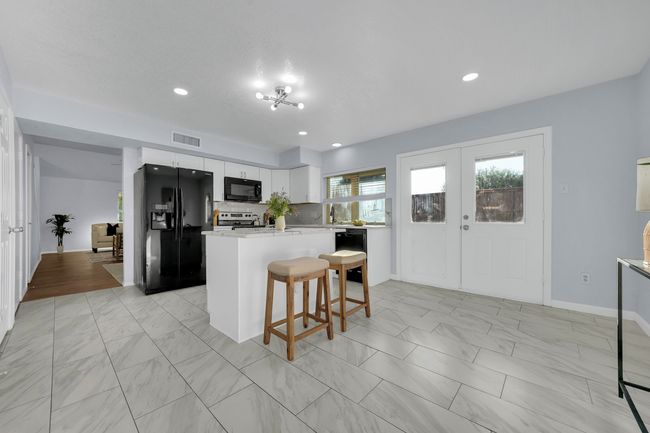 Kitchen featuring black appliances, light marble finish floors, light countertops, and recessed lighting | Image 26