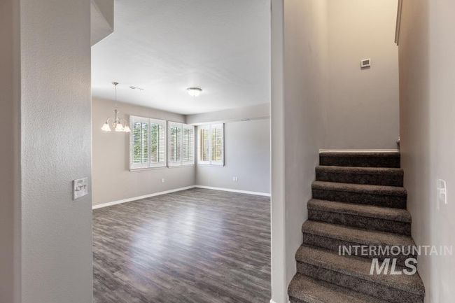 Staircase featuring wood finished floors and a chandelier | Image 4