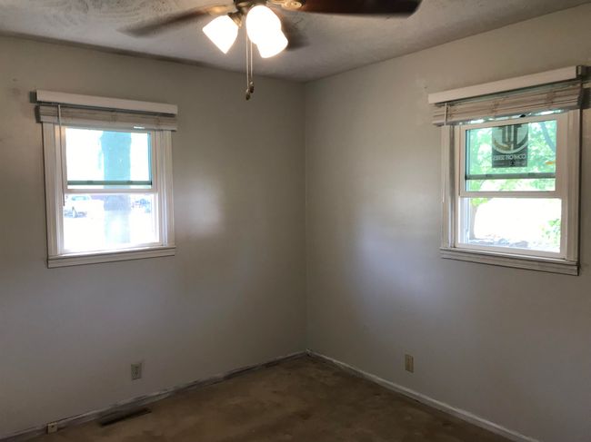 Spare room with ceiling fan, a wealth of natural light, visible vents, and baseboards | Image 8