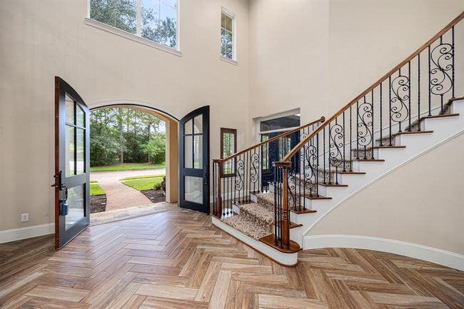 You are greeted with a formal foyer and wood-look ceramic plank tiling in a custom herringbone pattern. | Image 6