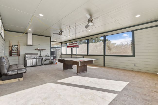 Game room with pool table, a wealth of natural light, and wood walls | Image 13
