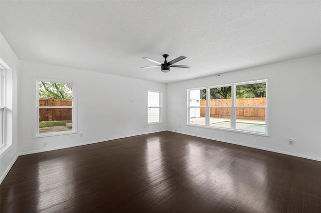 Spare room featuring ceiling fan, baseboards, and dark wood-style flooring | Image 15