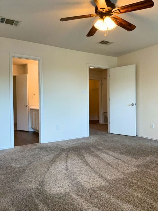 Primary bedroom with carpet, ensuite bath, and a ceiling fan | Image 19