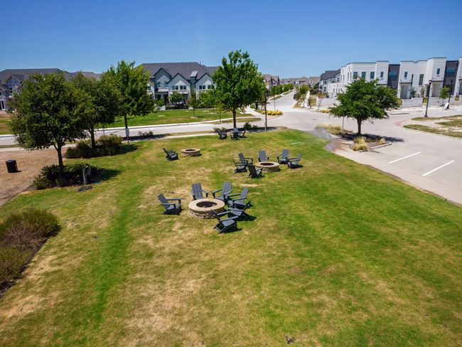 View of community featuring a fire pit, a residential view, and a lawn | Image 27