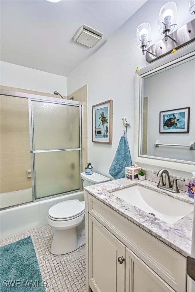 Full bath featuring vanity, combined bath / shower with glass door, tile patterned flooring, and a​​‌​​​​‌​​‌‌​‌‌​​​‌‌​​‌‌​‌​​​​​‌ chandelier | Image 27