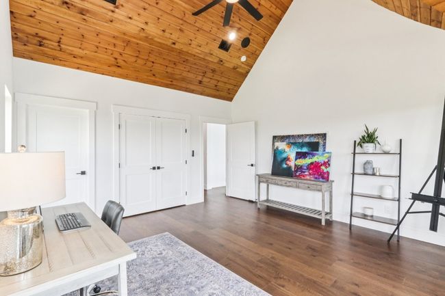 Home office featuring ceiling fan, wooden ceiling, high vaulted ceiling, and wood finished floors | Image 29