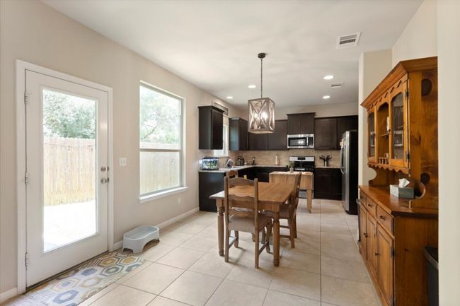 Eat-in kitchen provides space for a small table and china hutch, overlooking the yard. | Image 6