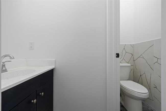 Bathroom featuring vanity, toilet, and tile walls | Image 15