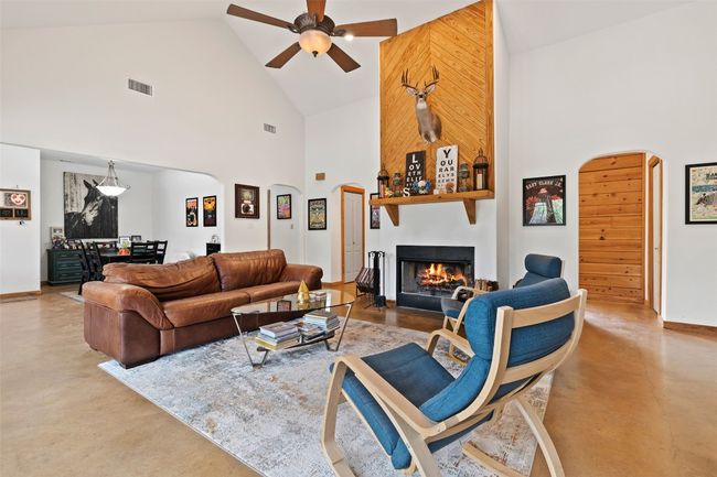 Living room with high vaulted ceiling and wood burning fire place | Image 11