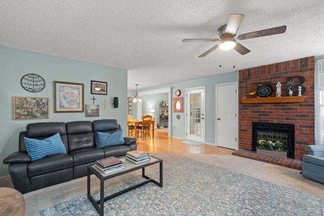 Step into the living room with a beautiful stone fireplace. | Image 5