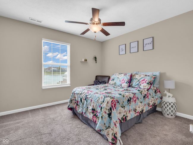 carpeted bedroom with visible vents, ceiling fan, and baseboards | Image 17