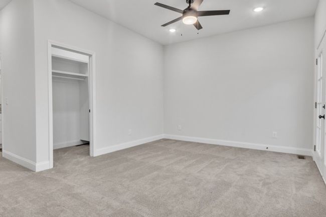 A shot back toward the entry and owner's closet featuring beautiful lighting and a modern fan & light. | Image 33