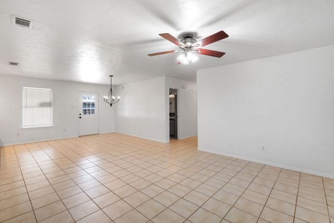 Unfurnished room featuring a chandelier, ceiling fan, and light tile patterned flooring | Image 11