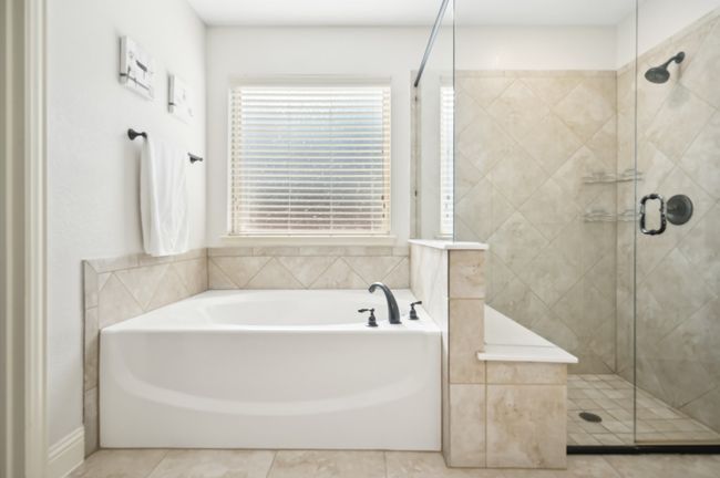 Full bathroom with tile patterned flooring, a bath, and a stall shower | Image 25