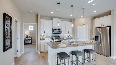 Open concept kitchen with ample countertop space and a large corner pantry. Model photo. Options and colors will vary. See listing agent for home specific selections. | Image 2