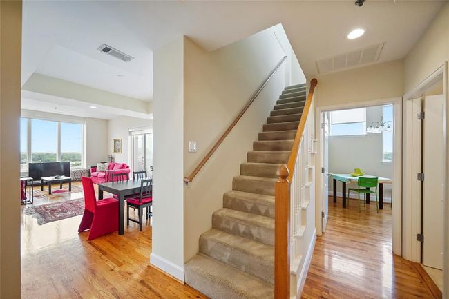 Spacious foyer with elegant staircase, offering seamless access to bright living and dining areas. | Image 4