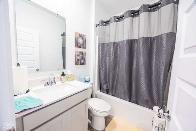full bath featuring vanity, shower / tub combo, and toilet | Image 16