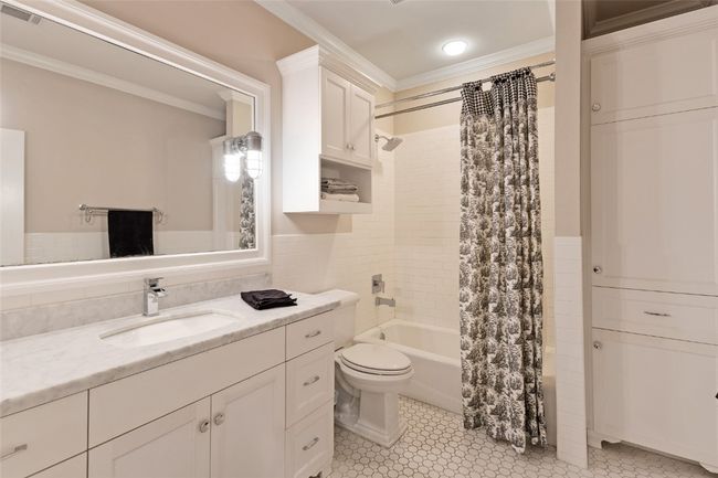 Bathroom with ornamental molding, shower / bath combination with curtain, toilet, vanity, and tile walls | Image 17