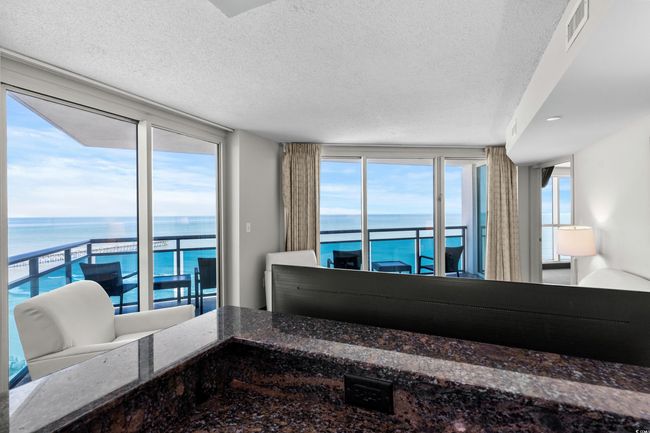 Bedroom featuring access to outside, multiple windows, visible vents, and a water view | Image 15