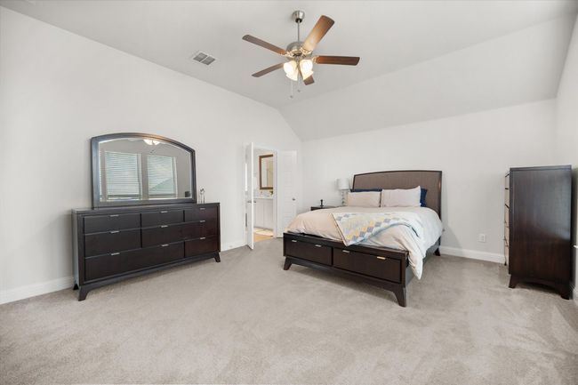 Carpeted bedroom featuring lofted ceiling, ceiling fan, and connected bathroom | Image 14