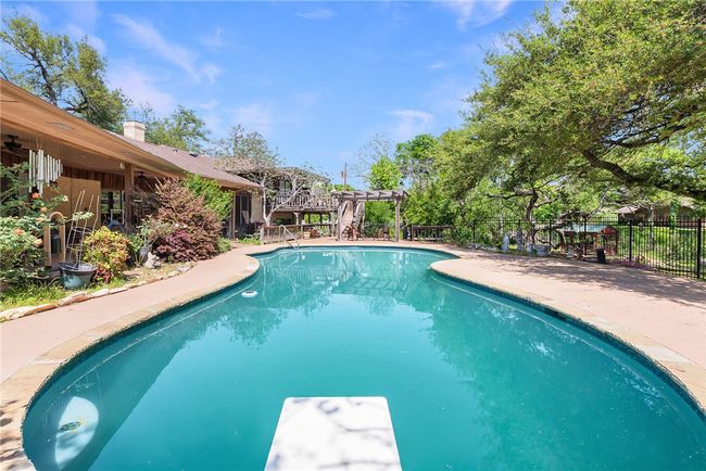 View of swimming pool with a pergola, a diving board, fence, and a fenced in pool | Image 37