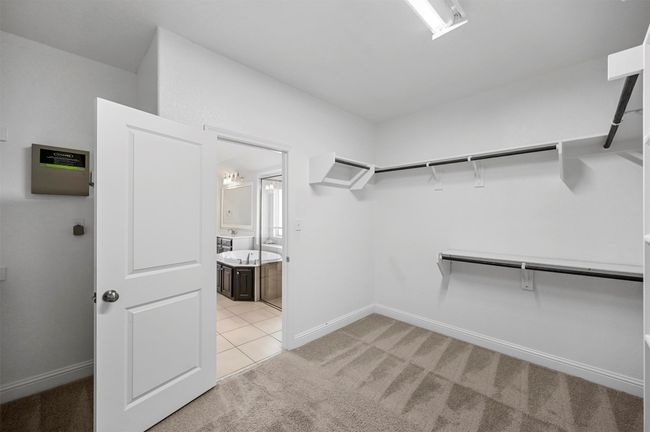 Walk in closet featuring light colored carpet | Image 30
