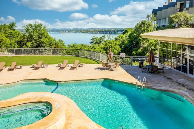 Community pool with a patio area, a community hot tub, a water view, and outdoor dining area | Image 29