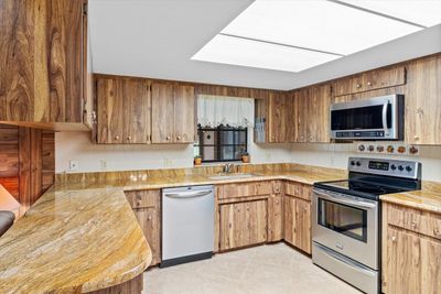 Kitchen Features Mid Century Modern Wood Style Laminate Cabinets w/ Granite Countertops, Stainless Steel Appliances, Dual Basin Sink, Tiled Backsplash & Recessed Lighting | Image 3