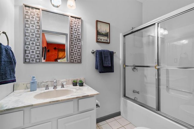 Full bath featuring enclosed tub / shower combo, tile patterned flooring, and vanity | Image 27