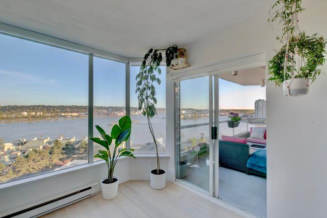 Sunroom with baseboard heating and a water view | Image 11