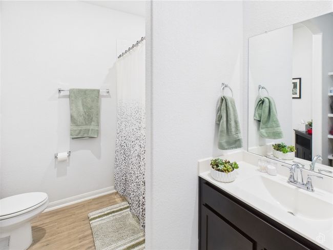 Bathroom featuring toilet, vanity, wood finished floors, baseboards, and curtained shower | Image 28