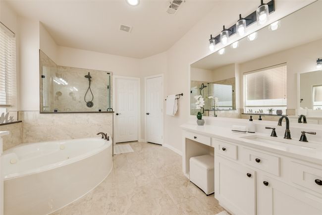 Full bath featuring tiled shower, a garden tub, vanity, and marble finish flooring | Image 20