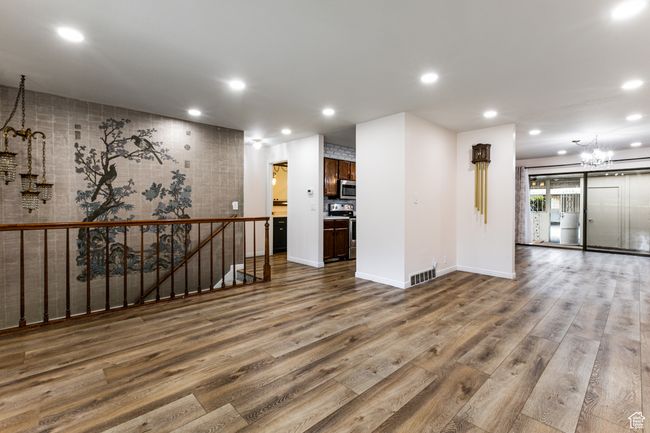 Spare room with a chandelier, wood finished floors, recessed lighting, and baseboards | Image 7