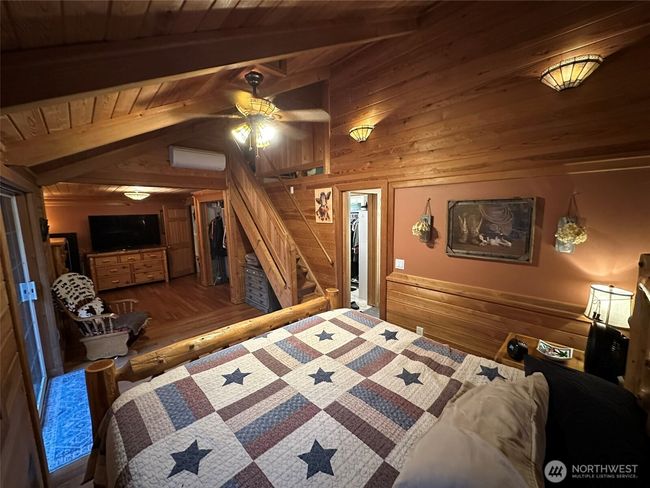 Wide angle shot of the master bedroom with stairs to loft/office and master bathroom with walk-in closet. | Image 16