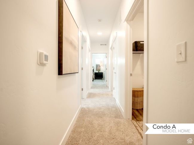Corridor with visible vents, baseboards, and light colored carpet | Image 10