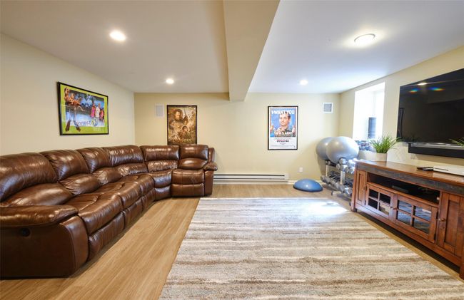 Living room featuring visible vents, wood finished floors, a baseboard heating unit, and recessed lighting | Image 27