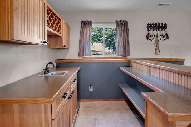 Laundry room featuring a sink and light tile patterned flooring | Image 23