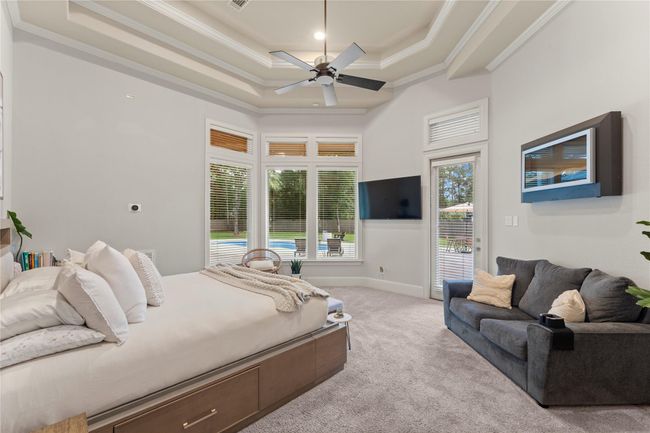 ...highlighted by elegant tiered ceilings and expansive windows that overlook the tranquil backyard, bringing in soft natural light and a sense of calm. | Image 26