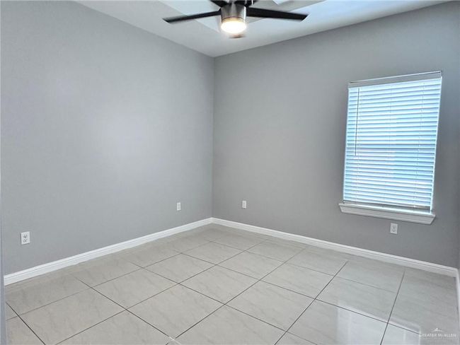 Spare room with light tile patterned flooring, baseboards, and ceiling fan | Image 14